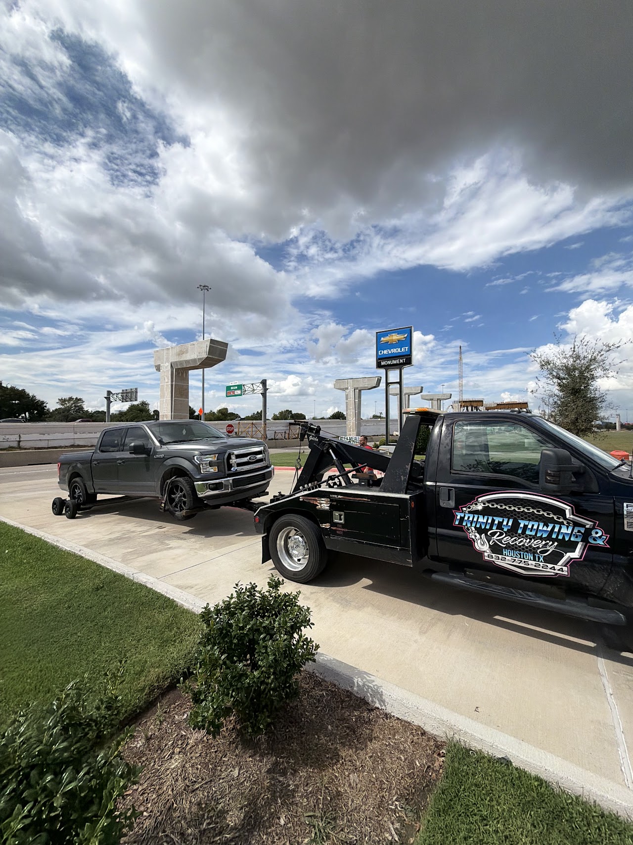 Our wheel-lift tow truck and a gray Ford pickup supported by rear dollies