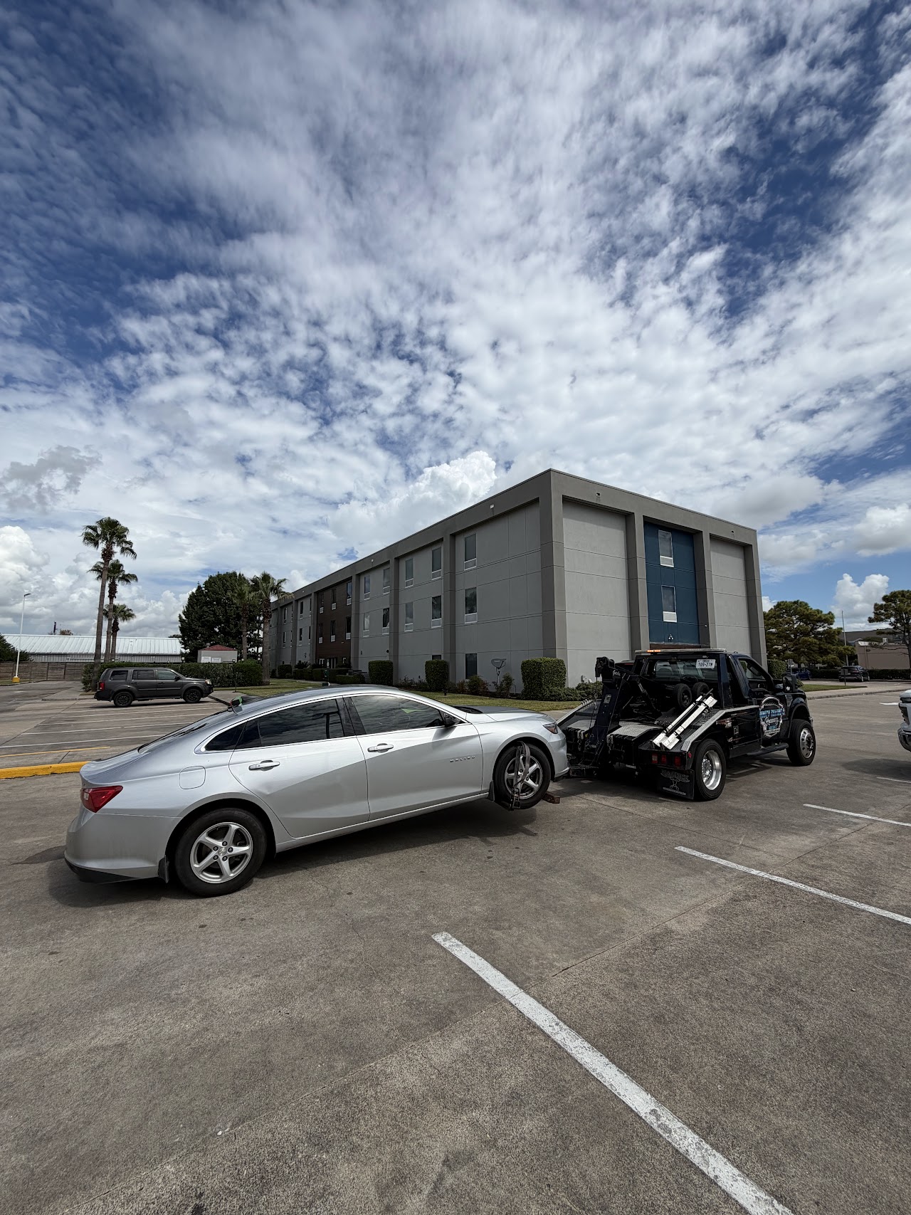 Silver Chevrolet Malibu with its front wheels supported by our wheel-lift