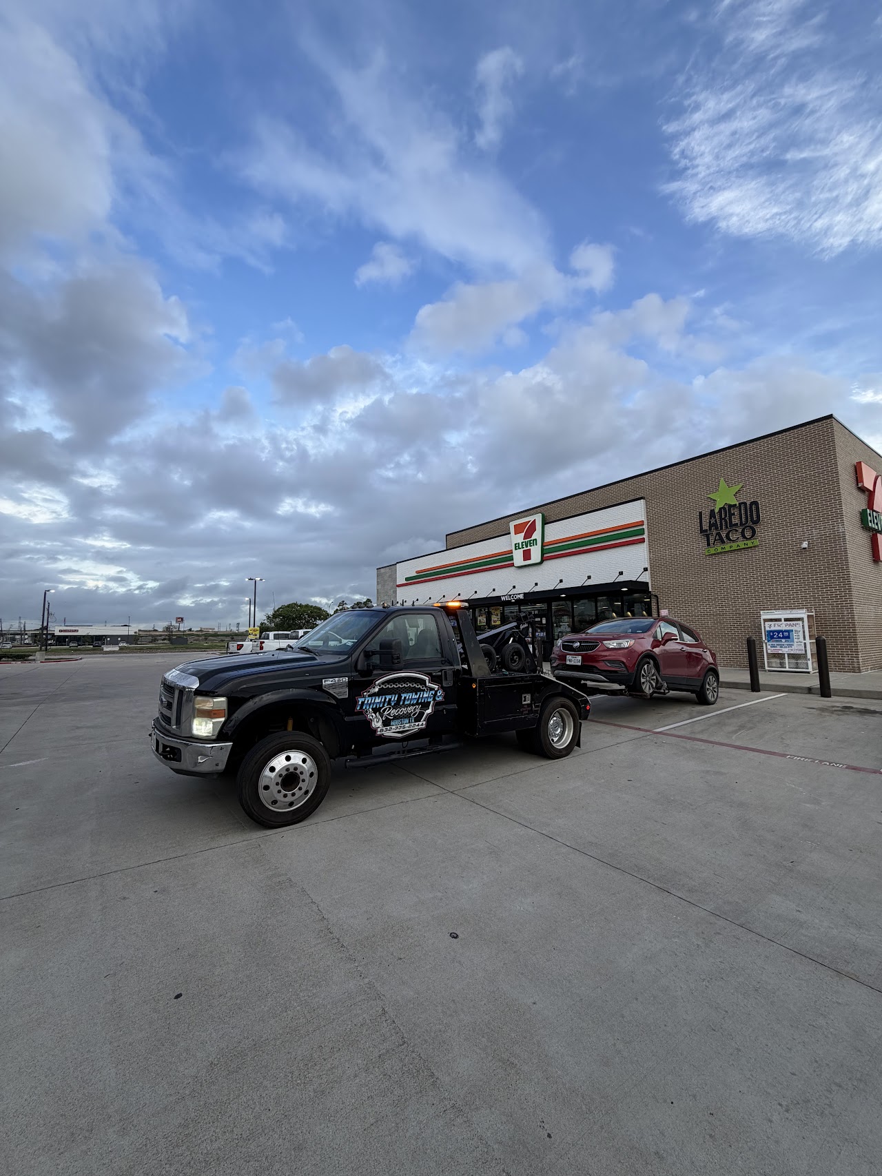 Our tow truck with a red SUV outside a convenience store